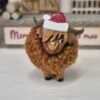 Small Highland Cow With a Santa Hat