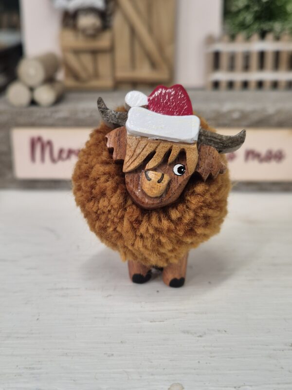Small Highland Cow With a Santa Hat